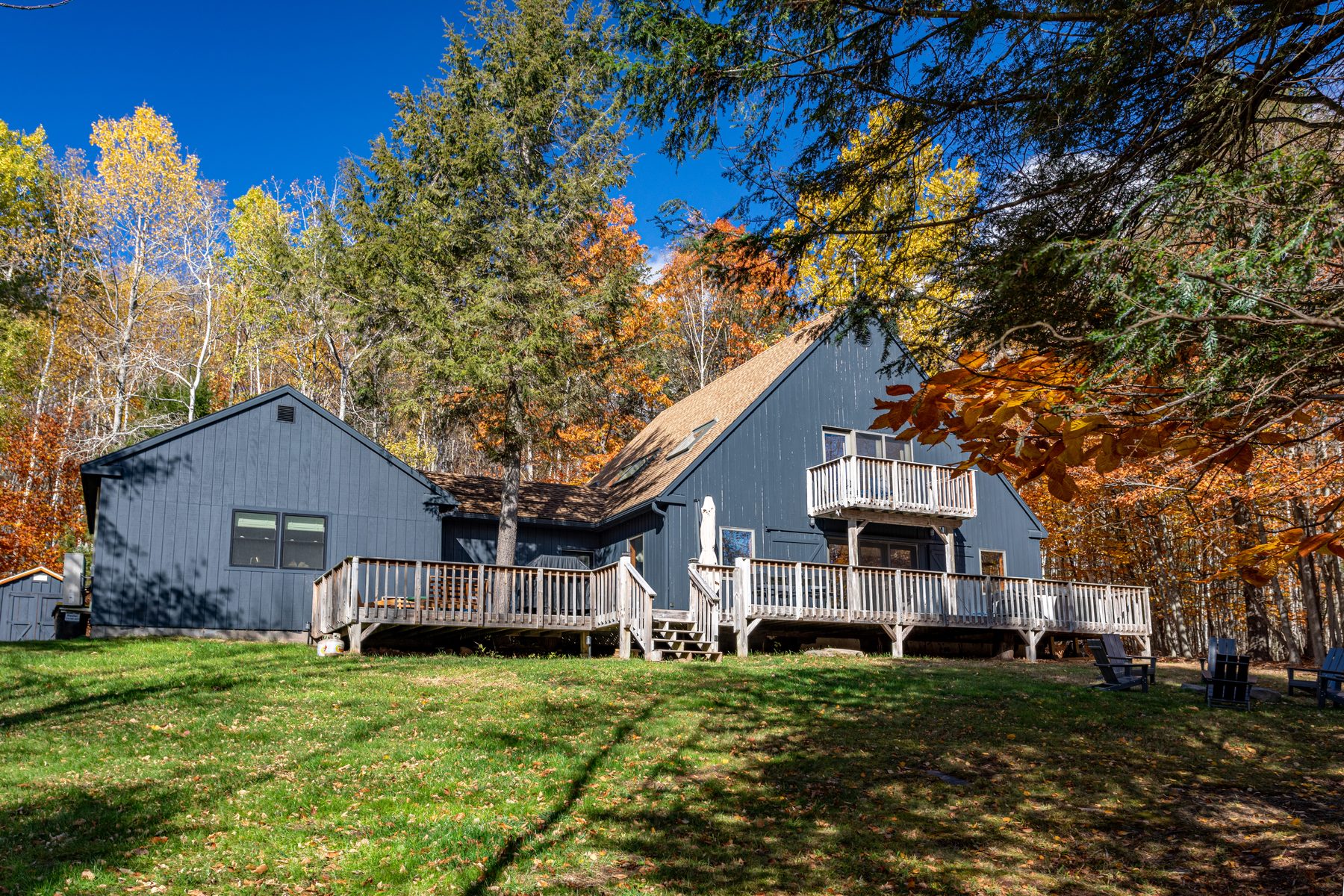 Blackberry Cottage, a gray A-frame framed by autumn foliage in Jewett, New York